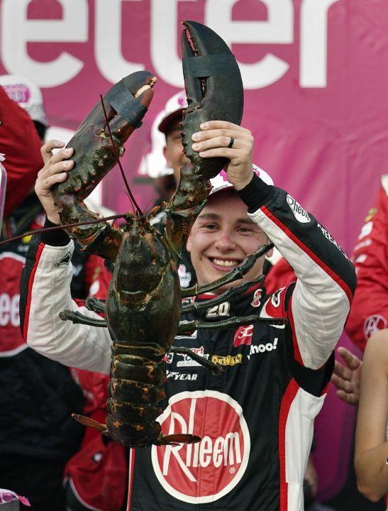 Christopher Bell holds up a giant lobster while celebrating after