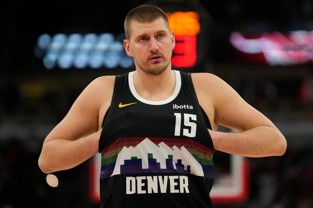 Denver center Nikola Jokic (15) sticks his hands in his jersey